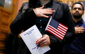 Candidates for US citizenship take the oath of allegiance during a Naturalization Ceremony